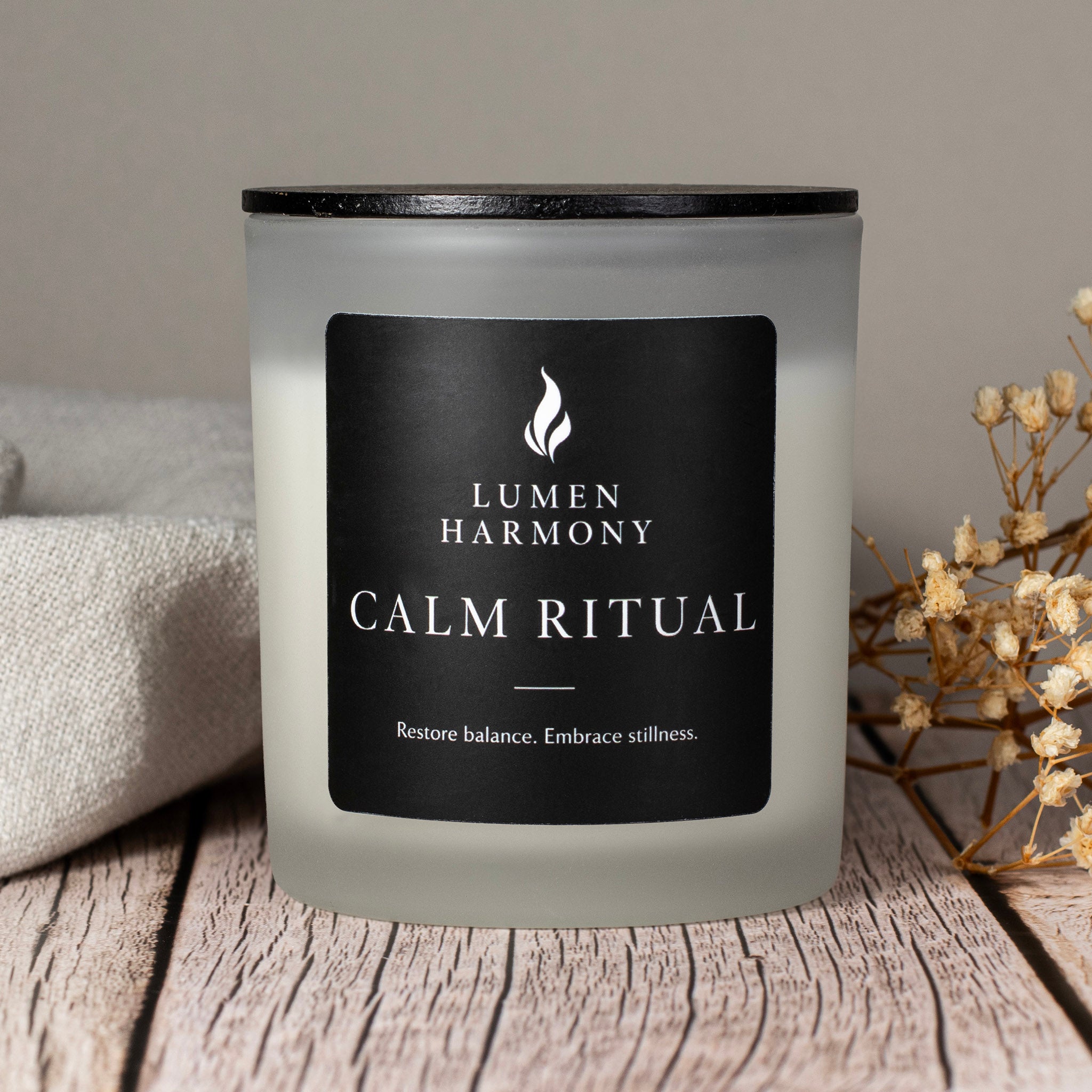 Candle labeled 'Lumen Harmony Calm Ritual' on a wooden surface with a neutral background