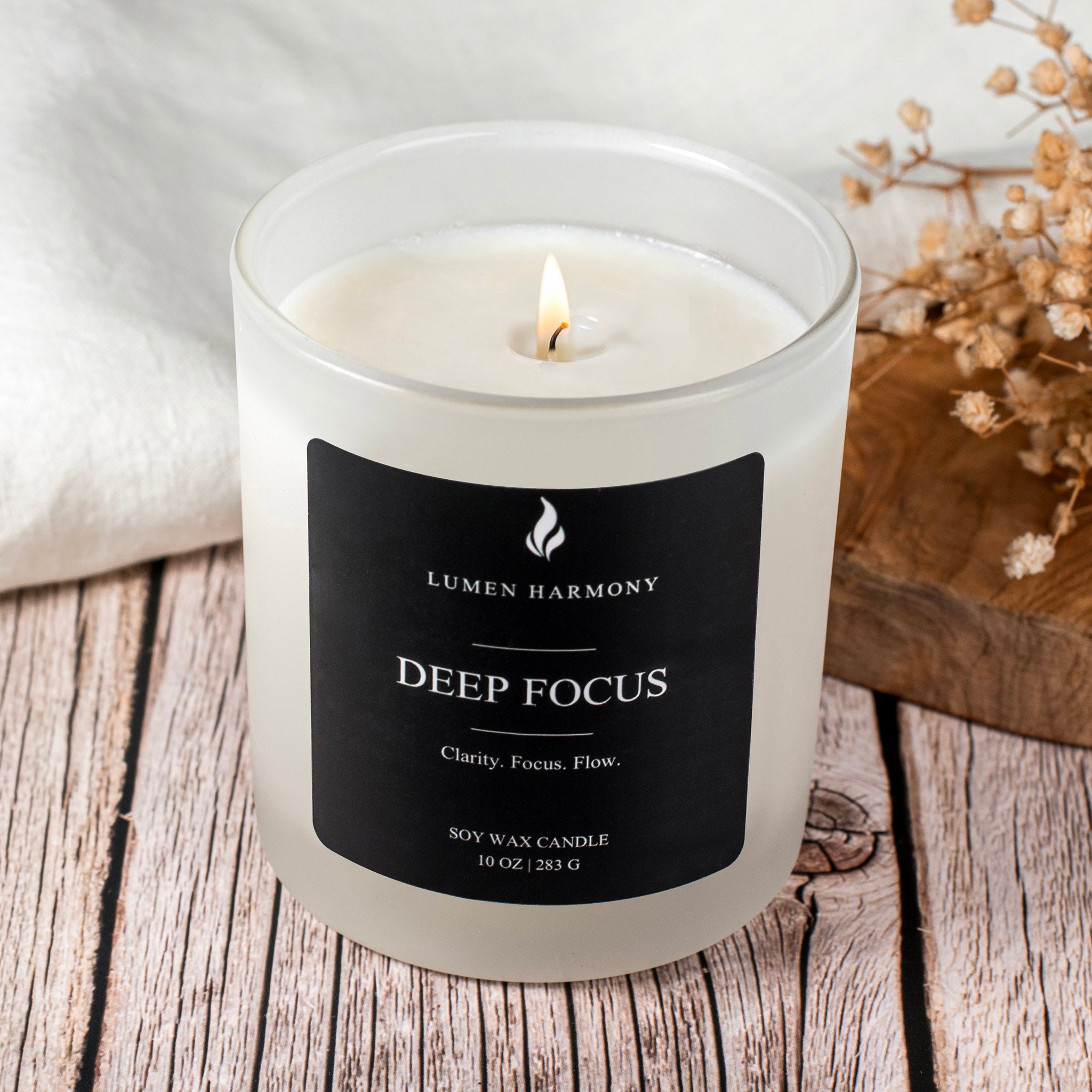 Luminous candle labeled 'Deep Focus' by Lumen Harmony on a wooden surface.