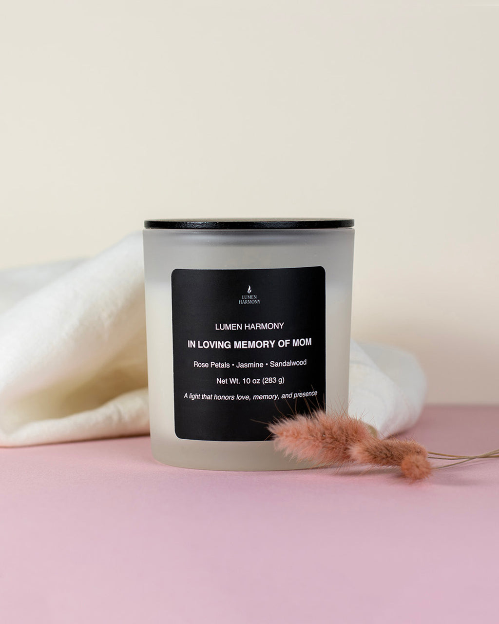 A candle called "in loving memory of Mom" in a pastel pallete color background