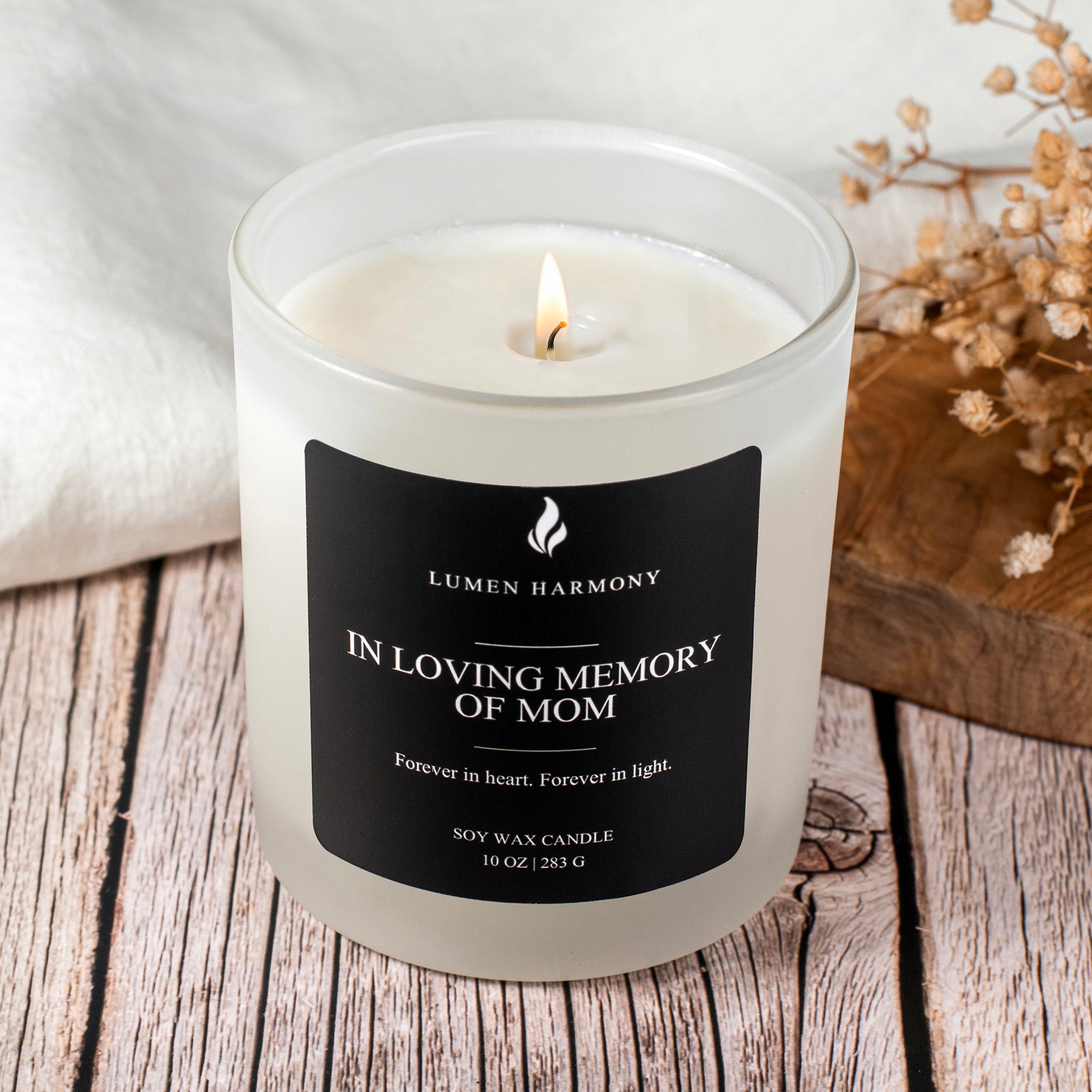 Candle with a black label on a wooden surface, featuring the brand 'Lumen Harmony'.