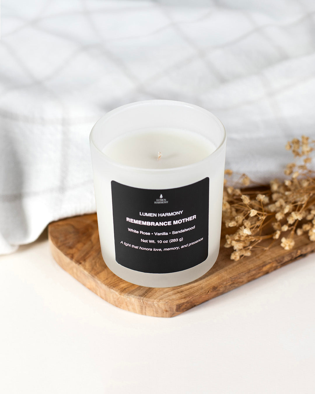 A candle called "Remembrance Mother" over a wooden piece of table