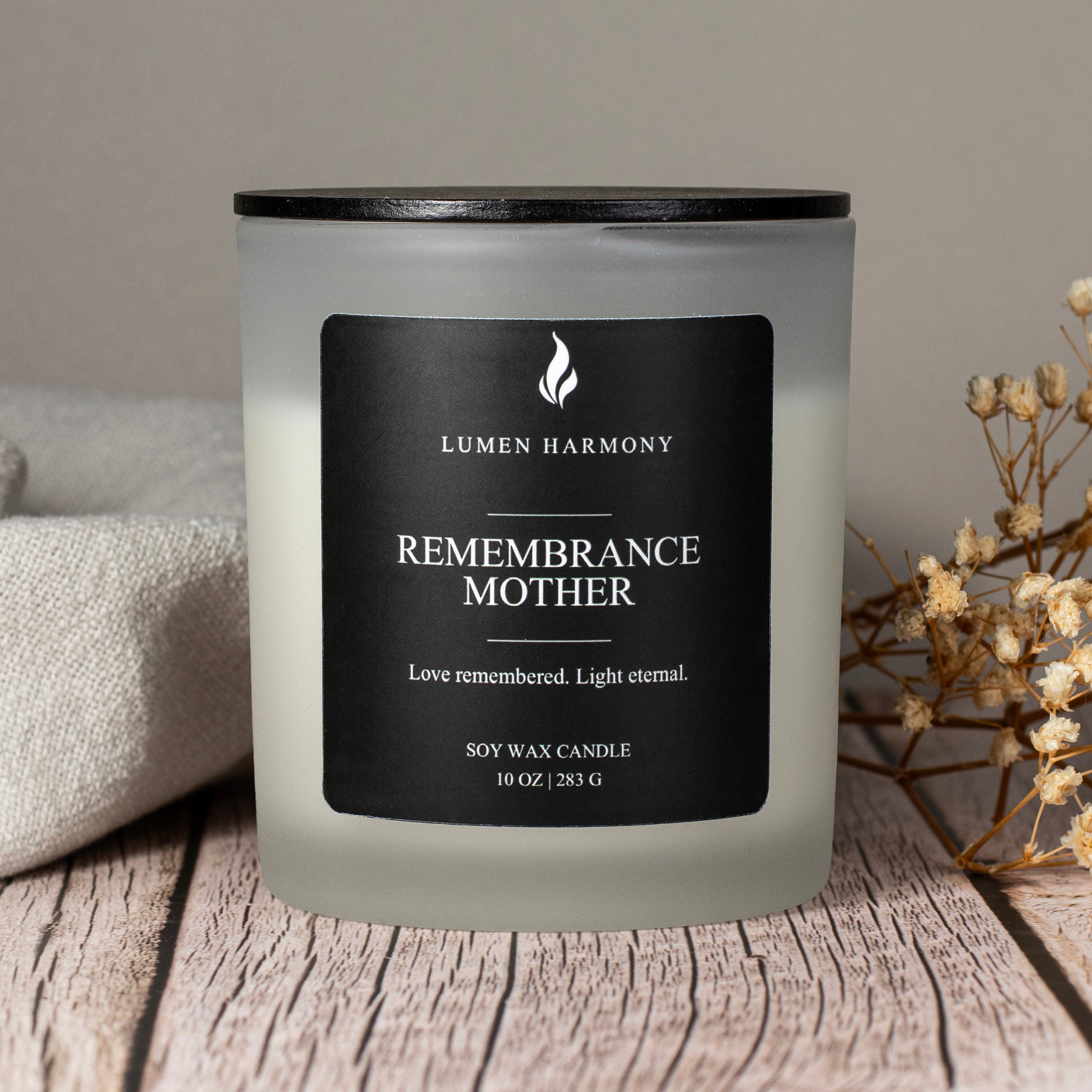 Frosted candle with a black label on a wooden surface, featuring the brand 'Lumen Harmony'.